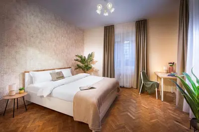 a bedroom with a large white bed and a desk at Central And Spacious Home in Sofia