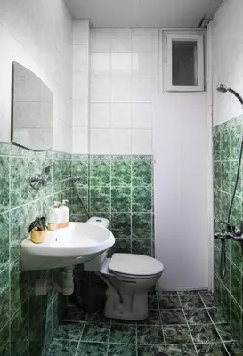 a green and white bathroom with a toilet and a sink at Central And Spacious Home in Sofia