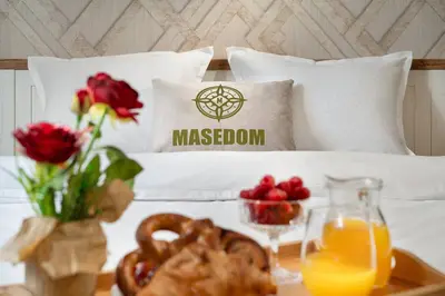 a bed with aessen pillows and a tray of fruit and flowers at Central And Spacious Home in Sofia