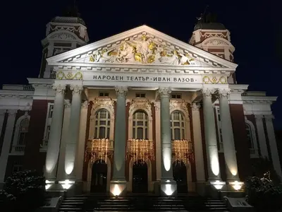 a large building with a sign on it at night at Central And Spacious Home in Sofia