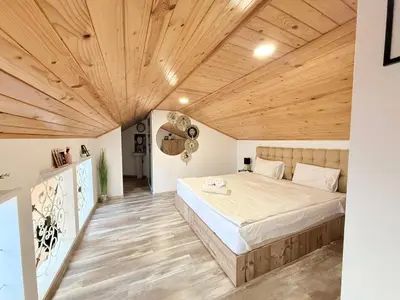 a bedroom with a large bed and wooden ceilings at Center Apartments The Quiet Luxury 7 in Plovdiv