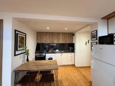 a kitchen with a wooden table and a refrigerator at Center Apartments The Quiet Luxury 7 in Plovdiv