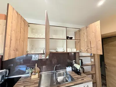 a kitchen with wooden cabinets and a sink at Central 2 Bedroom Apartments The Quiet Luxury 8 in Plovdiv
