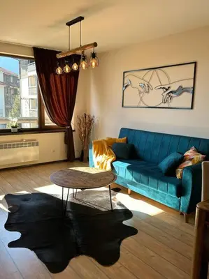 a living room with a blue couch and a table at Top location unique apartment in Bansko