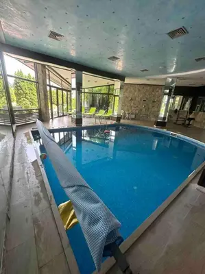 a large swimming pool with chairs in a building at Top location unique apartment in Bansko