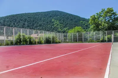 a tennis court with a mountain in the background at Balneocomplex Kamena in Velingrad