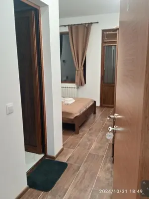 a room with a bed and a wooden floor at Стаи за гости Куцеви in Devin