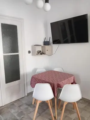 a dining room table with white chairs and a tv at My place in Sofia - Top center - 2 bedrooms - Self check-in in Sofia