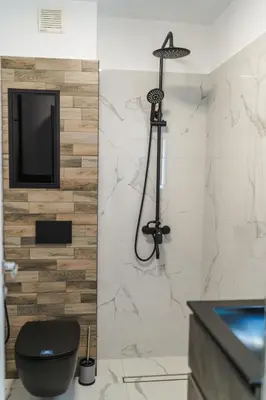 a bathroom with a toilet and a tv on a wall at Sweet Home 2 in Sandanski