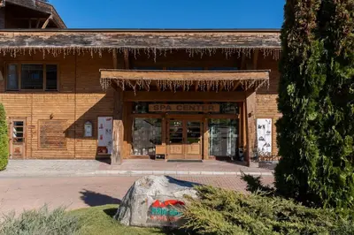 a building with a stone in front of it at Pirin Golf & Country Club Apartment in Bansko