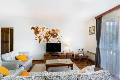 a living room with a couch and a tv at Pirin Golf & Country Club Apartment in Bansko