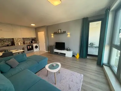 a living room with a blue couch and a table at Turquoise City Exotic Bliss in Sofia