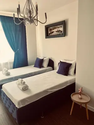 two beds sitting next to each other in a room at Бутиков Семеен Хотел БРИО in Velingrad