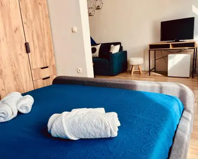 a bedroom with a blue bed with towels on it at Бутиков Семеен Хотел БРИО in Velingrad