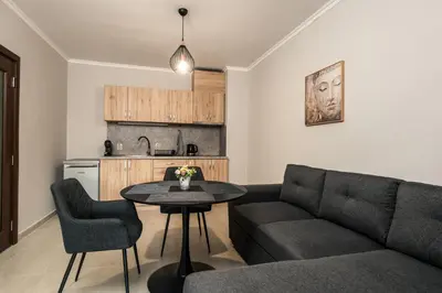 a living room with a couch and a table and a kitchen at Комплекс Стадиона in Velingrad