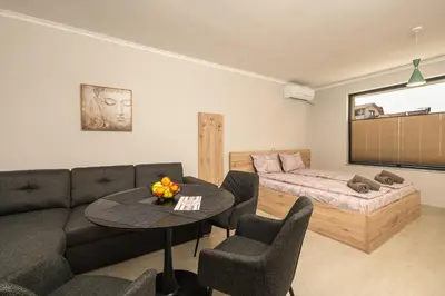 a living room with a couch and a bed and a table at Комплекс Стадиона in Velingrad
