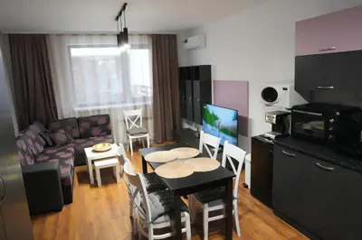 a living room with a couch and a table with chairs at Two-bedroom Apartment Paskalina, near the Ski lift in Bansko