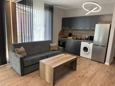 a living room with a couch and a refrigerator at Vimar Apartments in Panagyurishte