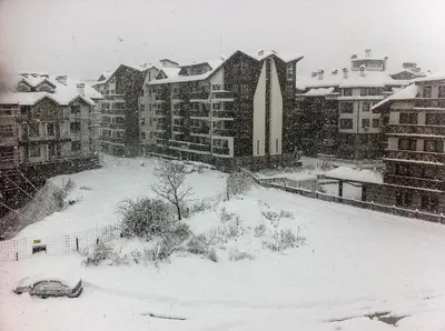 a snow covered city with a church and buildings at Penthouse 2 Bedroom Apartment w fireplace in Bansko