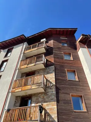 a tall building with balconies on the side of it at English Apartments in Bansko