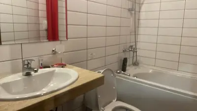 a bathroom with a sink and a toilet and a tub at English Apartments in Bansko
