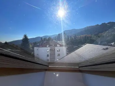 a view from the roof of a house with the sun in the sky at One bedroom ap 602 IN RILA PARK for 6 people in Borovets