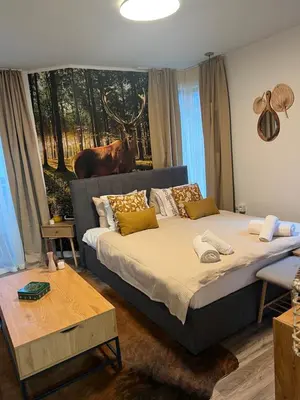 a bedroom with a bed with a cow painting on the wall at Luxury Studio1 in Hotel Friends in Bansko