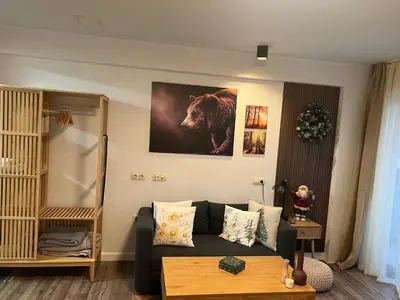 a living room with a couch and a picture of a bear at Luxury Studio1 in Hotel Friends in Bansko