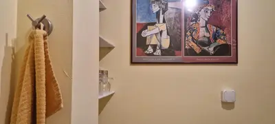 a bathroom with a picture of a woman on the wall at Peaceful studio in the city center, close to subway, Medical University in Sofia