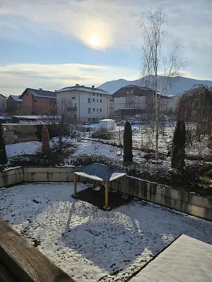 a bench sitting in the snow in a yard at Apartment Niko in Bansko