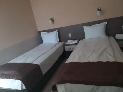 two beds in a hotel room withskirts at Family Hotel Relax in Strelcha