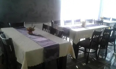 a dining room with two tables with white tablecloths at Family Hotel Relax in Strelcha