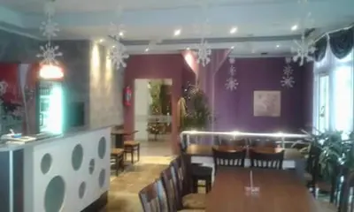 a restaurant with a table and chairs and purple walls at Family Hotel Relax in Strelcha