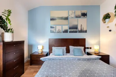 a bedroom with a large bed with blue pillows at The Snowmad Nest - Valentina Heights, 8 min from the gondola in Bansko