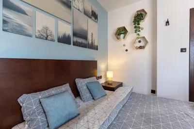 a bedroom with a large bed with blue pillows at The Snowmad Nest - Valentina Heights, 8 min from the gondola in Bansko