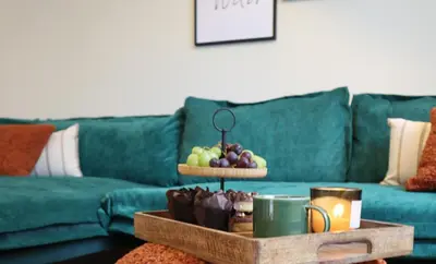 a living room with a green couch with a tray of fruit at Exquisite Euphoria apartment for 4 Guests in Borovets Ski Resort in Borovets