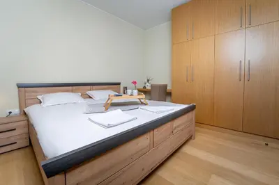 a bedroom with a large bed with wooden cabinets at Large One Bedroom Flat - Mountain Bliss in Borovets