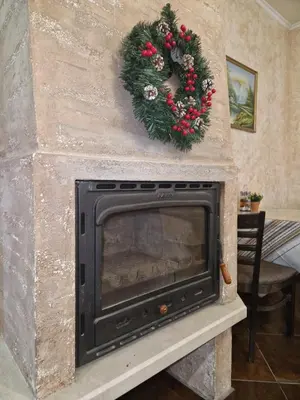 a fireplace with a christmas wreath on it at Хотел Релакс in Velingrad