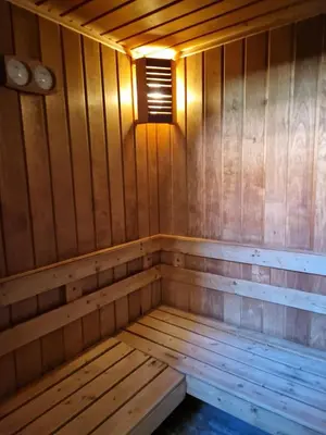 an empty wooden sauna with a light on it at Хотел Релакс in Velingrad