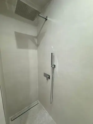 a white wall with a shower in a bathroom at The Urban Pearl in the Heart of Sofia next to National Palace of Culture in Sofia