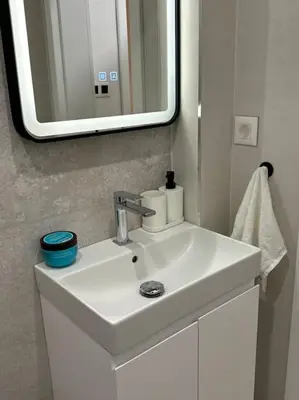 a bathroom with a white sink and a mirror at The Urban Pearl in the Heart of Sofia next to National Palace of Culture in Sofia