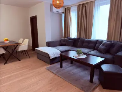 a living room with a blue couch and a table at Florimont Heights Apart Complex in Bansko