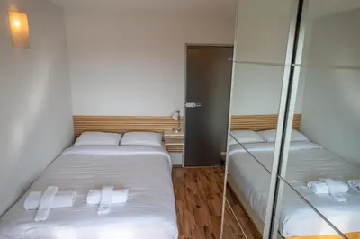 two beds in a small room with mirrors at Bright 1BDR with Balcony in Sofia