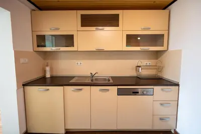 a small kitchen with white cabinets and a sink at Bright 1BDR with Balcony in Sofia
