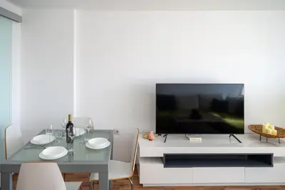 a dining room with a table and a tv at Bright 1BDR with Balcony in Sofia