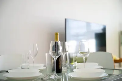 a table with glasses and a bottle of wine at Bright 1BDR with Balcony in Sofia