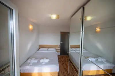 two beds in a small room with mirrors at Bright 1BDR with Balcony in Sofia