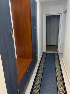 a hallway with a wooden cabinet and a blue rug at Лунара in Sandanski