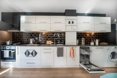 a kitchen with white cabinets and a washer and dryer at Host2U New Inn 2 BD, Fireplace, Free parking in Bansko