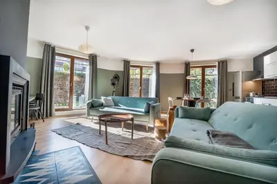 a living room with two blue couches and a fireplace at Host2U New Inn 2 BD, Fireplace, Free parking in Bansko